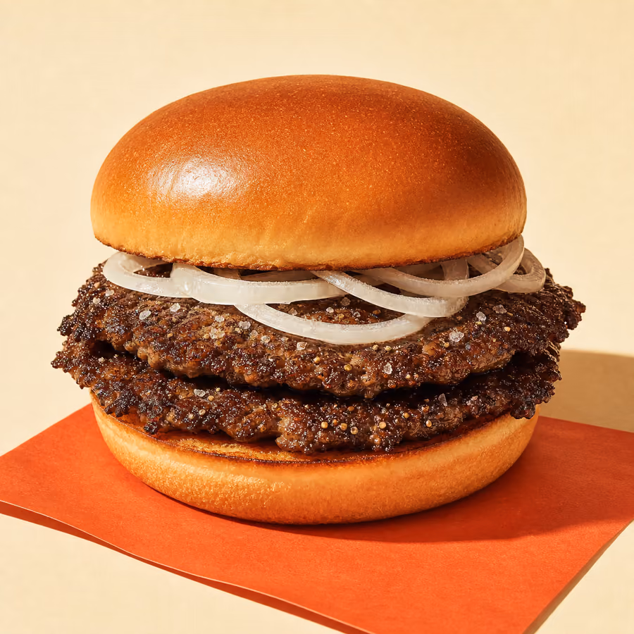 Puristischer Salt-&-Pepper-Smash: zwei Patties mit dunkler Salz-Pfeffer-Kruste und rohen Zwiebelringen im Brioche-Bun, ohne Sauce und Käse